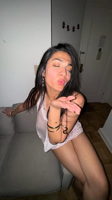 Blowing a kiss, wearing stacked gold cuffs